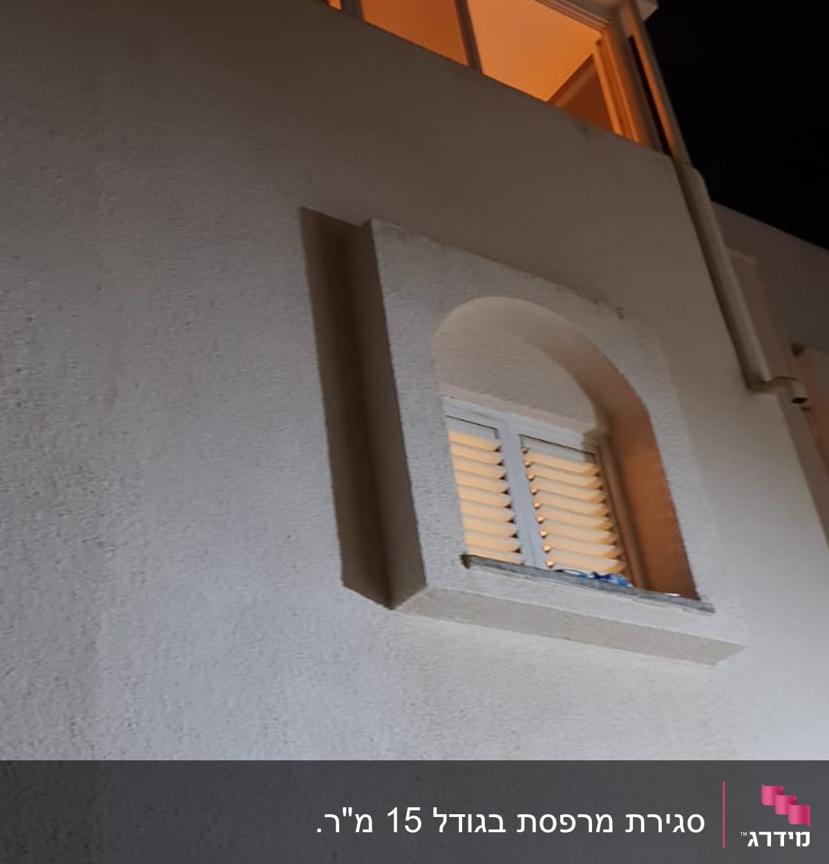 חלונות אלומיניום מוארים בקומה עליונה של בניין